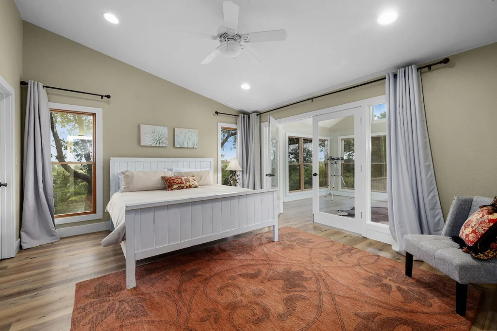Barn House queen bedroom — sage walls and french doors