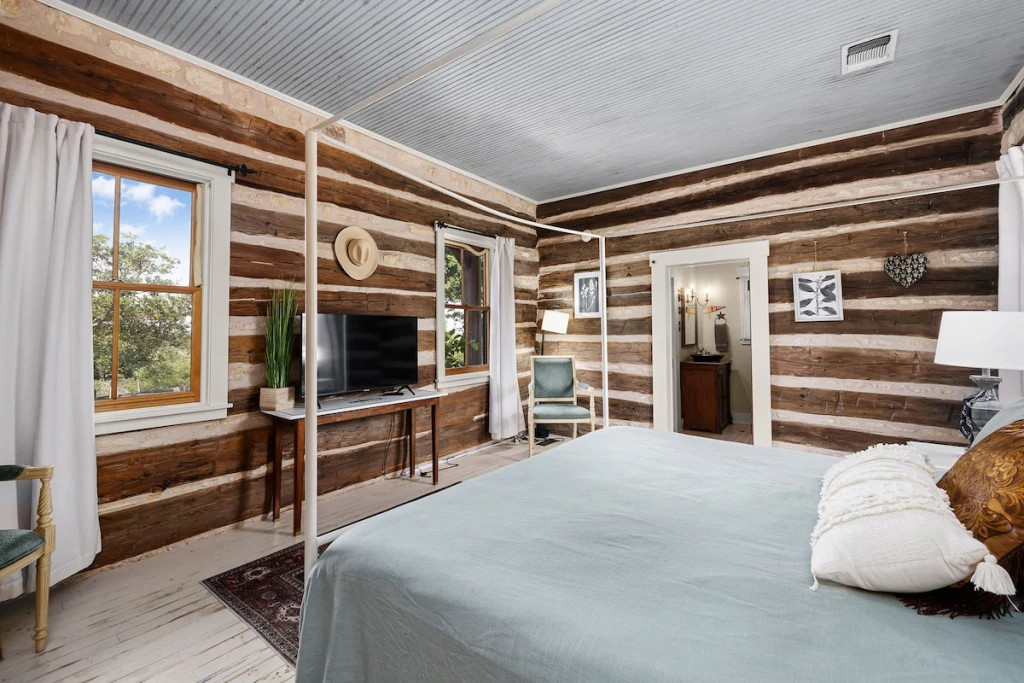 Cowgirl Cabin interior — second angle showing log walls and windows