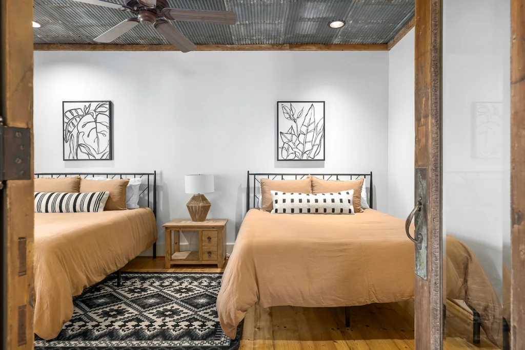 Main House second bedroom — two queen beds with warm rustic details