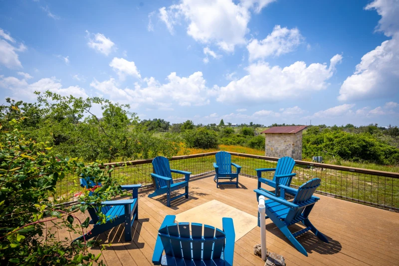 Wide angle of the Adirondack deck with stone outbuilding and Hill Country