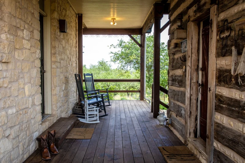 Cowgirl Cabin stone porch with a wooden rocking chair and boots