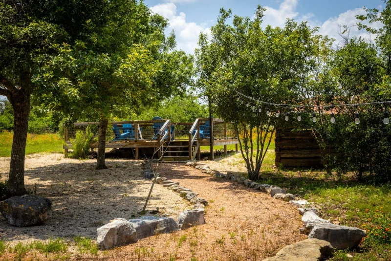 Stone garden path through native landscaping toward the deck