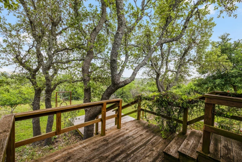 Wooden overlook deck surrounded by live oaks with creek view