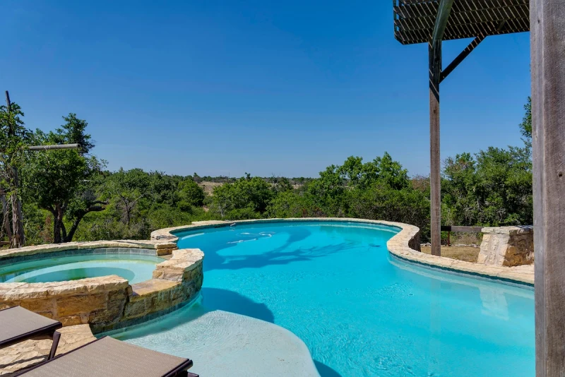 Pool and hot tub with the full Hill Country view beyond the edge