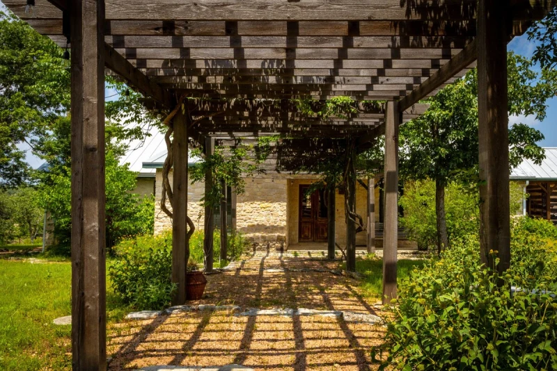 Stone pergola walkway leading to the Main House entry