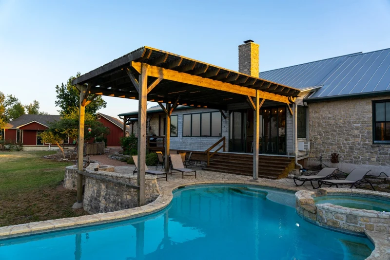 Main House from the pool side showing the stone walls and pergola